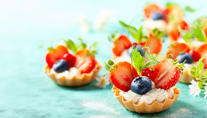 Summer berry tartlets  with cream and fresh berries.