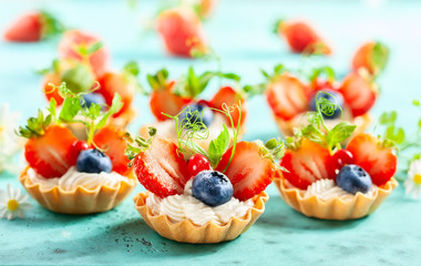 Summer berry tartlets  with cream and fresh berries.