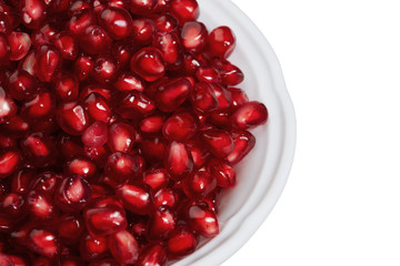 Pomegranate seeds in a bowl isolated on white background. Top view, close-up