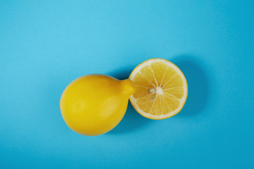 Whole lemon and half a lemon on a light blue background