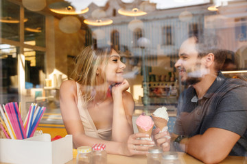 Happy couple in love eating ice cream in cafe
