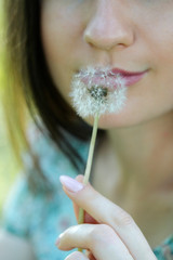 woman playing with a dandelion in the meadow, close-up, lips and dandelion women large
