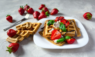 Belgium waffles dessert with strawberries, basil, ricotta cheese and chocolate.