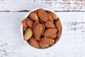 A small bowl with almond at white background