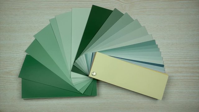 All colors in color swatches book. Isolated on wooden background. Picking color in interior design.