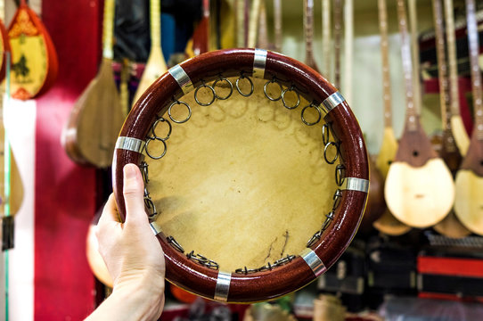 Central Asian traditional musical instrument tambourine. Uzbek doira in a hand