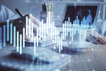 Financial chart drawn over hands taking notes background. Concept of research. Double exposure