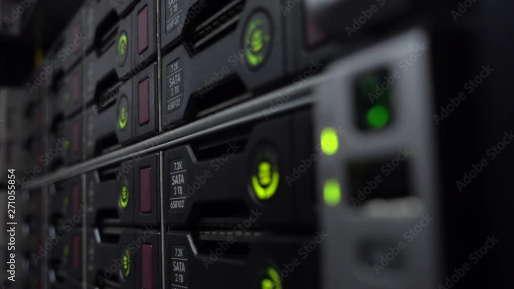 Poster rack data server with many hard drives and green led lamps blink