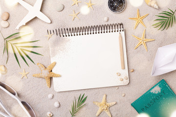 Travelers notebook with accessories on sand background top view. Planning summer holidays, trip and...