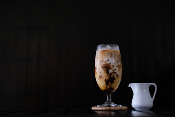 Iced coffee with fresh milk on wooden table