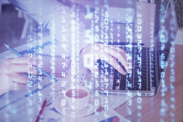 Multi exposure of data internet theme hologram with man working on computer on background. Concept of innovation.