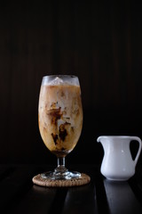 Iced coffee with fresh milk on wooden table