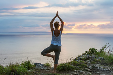 Caucasian woman practicing yoga at seashore