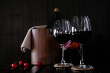 Close up wine glasses and bottles on wooden background