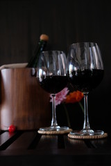 Close up wine glasses and bottles on wooden background