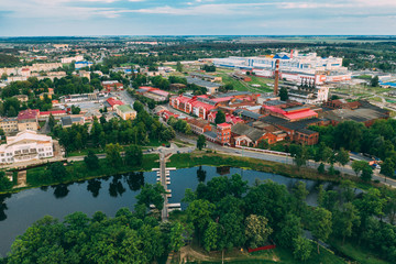 Fototapeta na wymiar Dobrush, Gomel Region, Belarus. Aerial View Of Old Paper Factory Tower In Spring Day. Historical Heritage In Bird's-eye View
