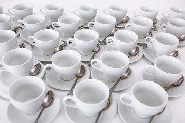 White dishes: cups and saucers for tea or coffee on a white background. View from above. Isolated object. A lot of dishes on a white background. A concept of still life.