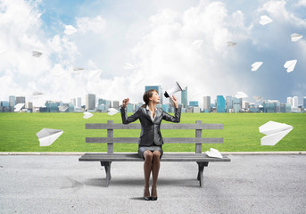 Young woman with megaphone on wooden bench