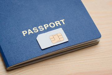 Biometric passport and SIM card on a wooden background. Registration and identification SIM card...