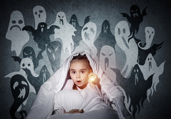 Surprised girl hiding under blanket