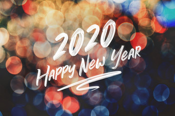 Brush stroke handwriting 2020 happy new year on abstract festive colorful bokeh light background,holiday greeting card.