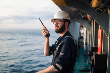 Deck Officer on deck of offshore vessel or ship , wearing PPE personal protective equipment. He...