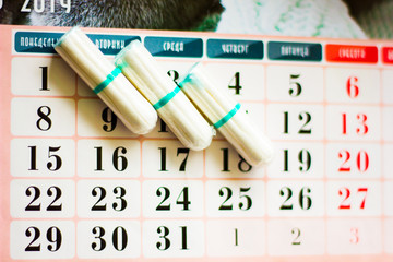 The concept of critical days, menstruation. Tampons on the calendar grid.