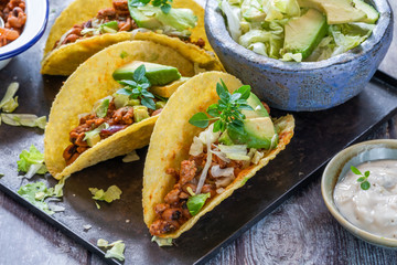 Smoky Mexican pork and bean tacos with lettuce and avocado salad