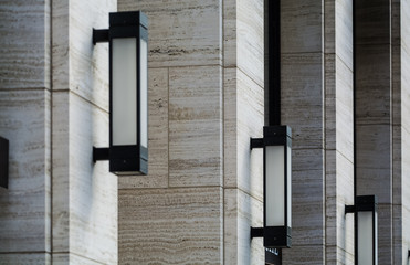Background or texture from gray stone columns and rectangular street wall lamps from metal and...