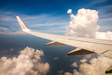 Fototapeta na wymiar Wing of airplane in cloudy sky