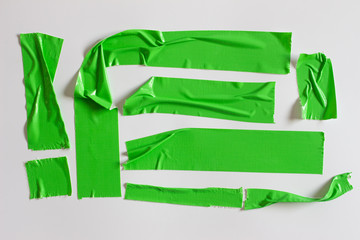 Set of green tapes on white background. Torn horizontal and different size green sticky tape, adhesive pieces.