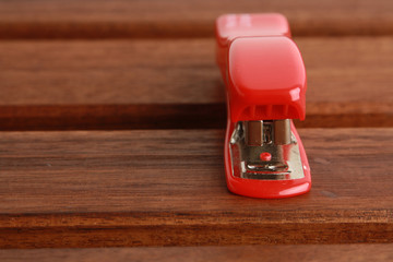 red stapler on wooden background
