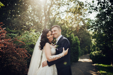 Beautiful bride and groom embracing and kissing on their wedding day.