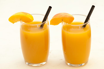  peach juice glasses on white table  backdrop