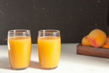two peach juice glasses on black