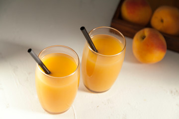 two peach juice glasses on white from above