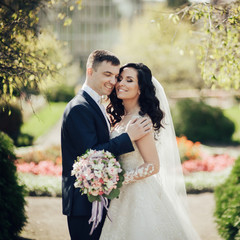 Beautiful bride and groom embracing and kissing on their wedding day.
