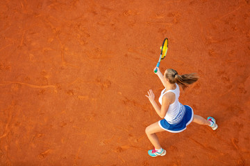 Aerial shot of a female tennis player on a court during match. Young woman playing tennis.High...