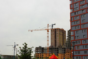 Fototapeta na wymiar view from the yard to the construction site where the tower crane