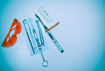 Professional Dentist tools: dental mirror, probe, syringe, tip with bur, LED lamp, goggles, etc. Dental Hygiene and Health conceptual image