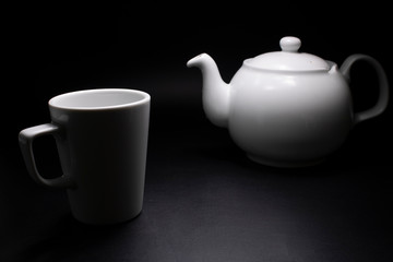 ahead of sugar cube and porcelain mug in background and teapot