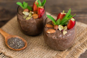Beautiful and tasty dessert with cocoa, strawberry and seeds of a chia. A fresh pudding with fruit for breakfast