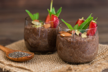 Beautiful and tasty dessert with cocoa, strawberry and seeds of a chia. A fresh pudding with fruit for breakfast