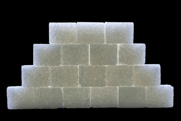 Sugar cubes lined up in pyramid shape. Black background