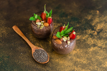 Beautiful and tasty dessert with cocoa, strawberry and seeds of a chia. A fresh pudding with fruit for breakfast