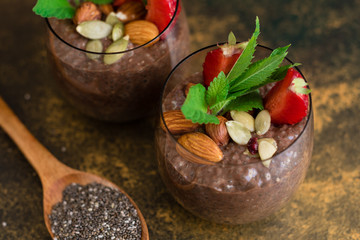 Beautiful and tasty dessert with cocoa, strawberry and seeds of a chia. A fresh pudding with fruit for breakfast