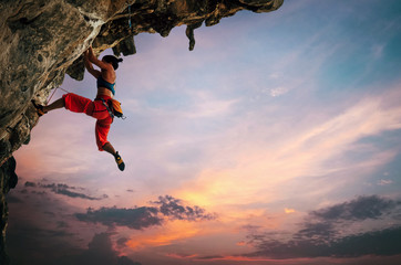 Woman climbing on rock - obrazy, fototapety, plakaty