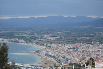 View of the sea and a small town on a hill near the coast.