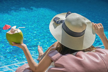 Obraz premium Women are relaxing at the poolside. woman relaxing in swimming pool spa. Cute girl is relaxing in the pool.Relax spa.