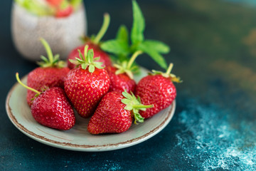 Beautiful and tasty dessert with a kiwi, strawberry and seeds of a chia. A fresh pudding with fruit for breakfast